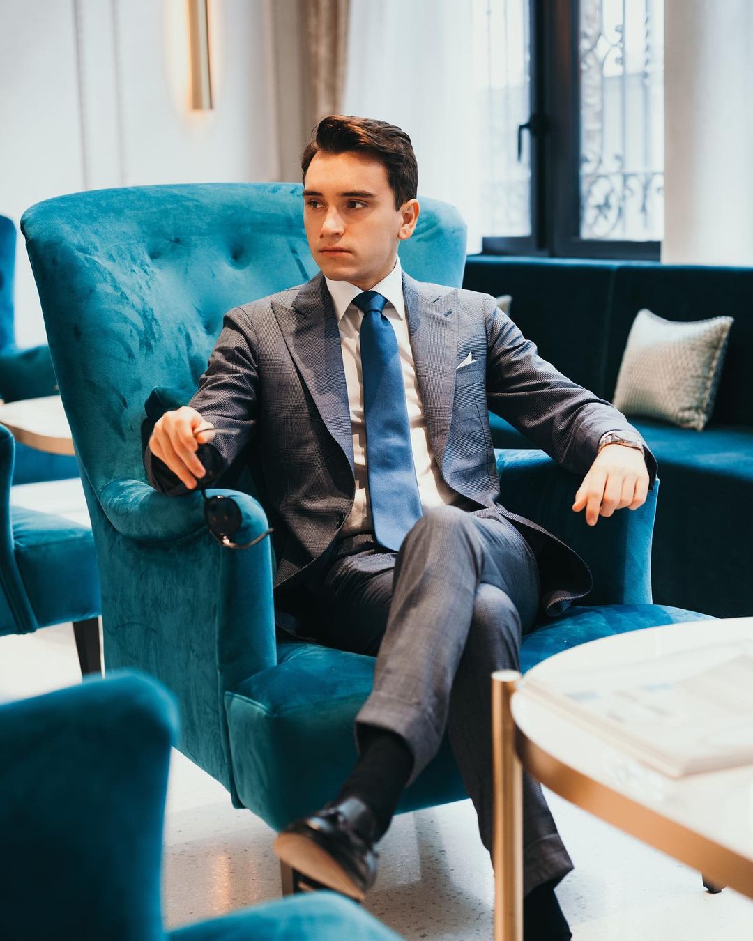 young man in suit sat in arm chair shoe shine lotion review shinebuddi